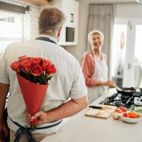Roses, gift and senior couple love flowers to celebrate their marriage anniversary in a romantic wa